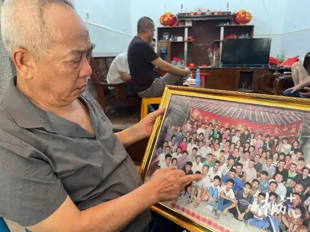 吴父拿着老照片回忆。 南方+ 余丹 拍摄 图片